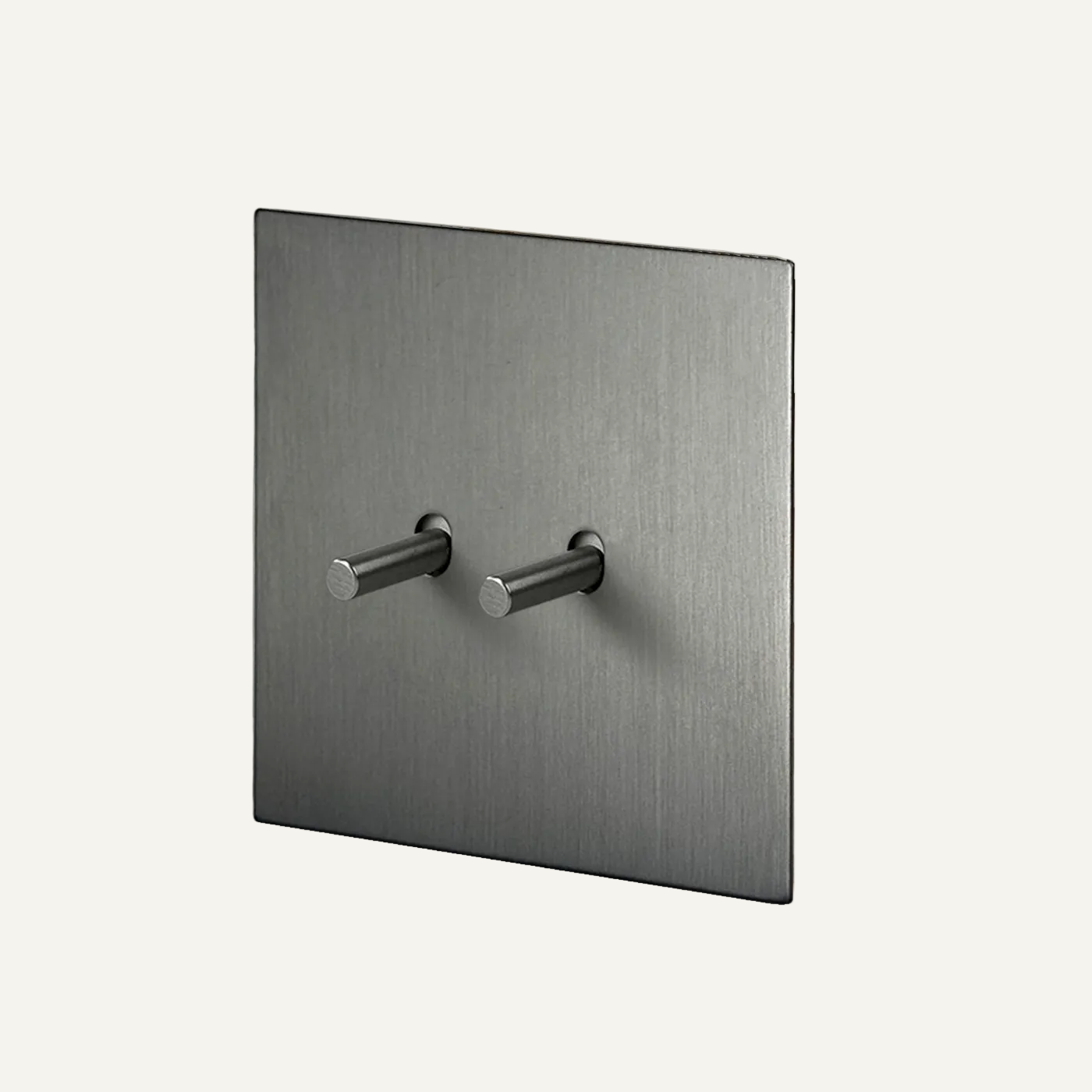 Metallic square wall plate with two knobs on a light gray background