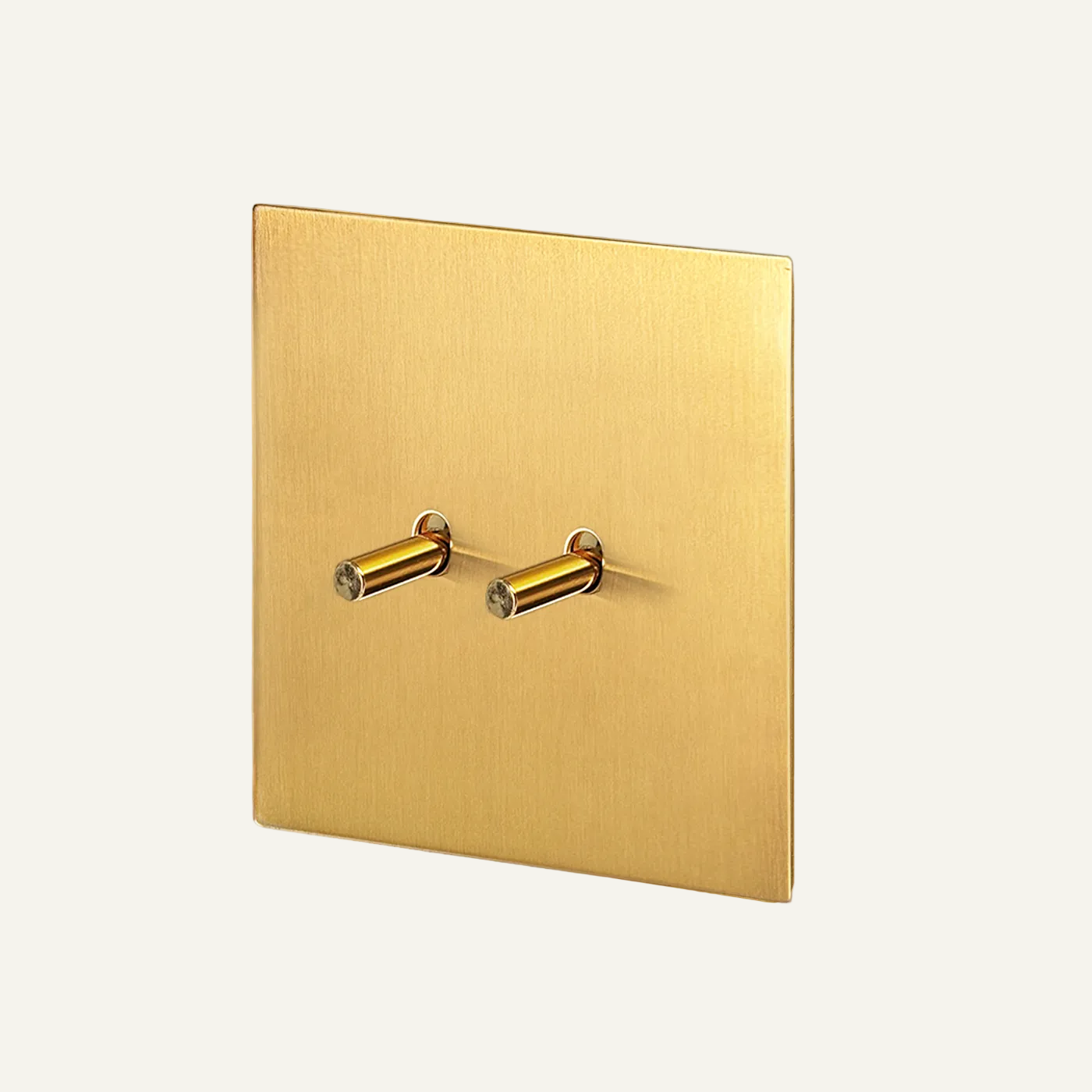 Gold square wall plate with two knobs on a gray background