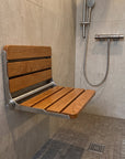 Luxworth Oak folding shower seat with wooden finish, compact design, and sturdy metal frame for safe bathroom seating.
