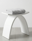 Luxworth stone arched shower stool with smooth solid surface and curved design for bathroom seating.